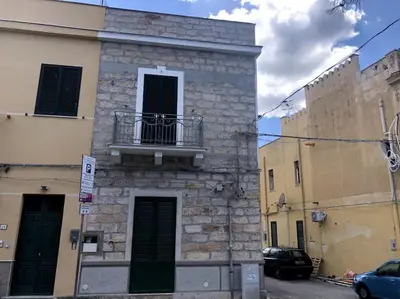 a building with a balcony on the side of it at La casa di Maria in Isola delle Femmine