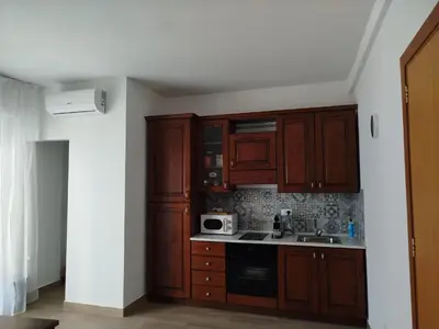 a kitchen with wooden cabinets and a microwave at Mondello Sea House in Palermo