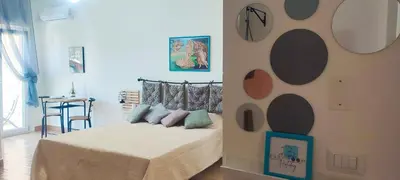 a bedroom with a bed with a wall with circles at Easy Room Holiday in Castellammare del Golfo