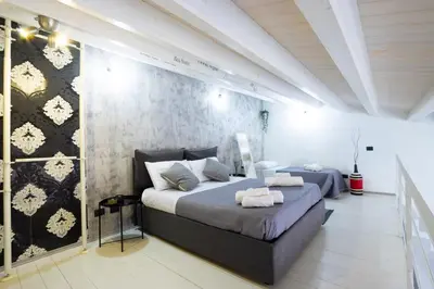 a bedroom with a large bed and a wall at Pozzillo appartament -near the cathedral in Monreale