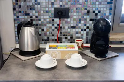 a counter top with a coffee maker and plates on it at Pozzillo appartament -near the cathedral in Monreale