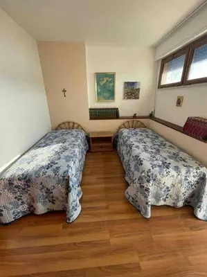 two beds in a room with wooden floors at La Scalinatella di Mondello in Palermo