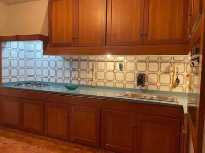 a kitchen with wooden cabinets and a counter top at La Scalinatella di Mondello in Palermo