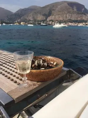 a bowl of shells and a glass on a table on a boat at La Scalinatella di Mondello in Palermo