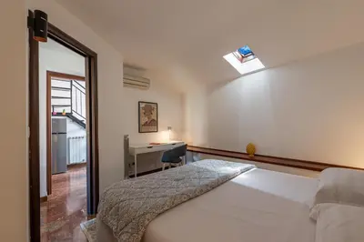 a bedroom with a bed and a desk and a window at Le terrazze nel cuore della Kalsa by Wonderful Italy in Palermo
