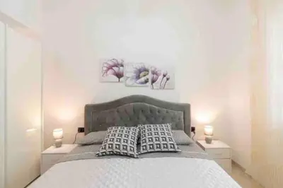 a bedroom with a bed with two night stands and two lamps at Casa vacanze Elisir Del Golfo in Alcamo