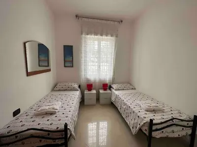two twin beds in a room with a window at Casa vacanze Elisir Del Golfo in Alcamo