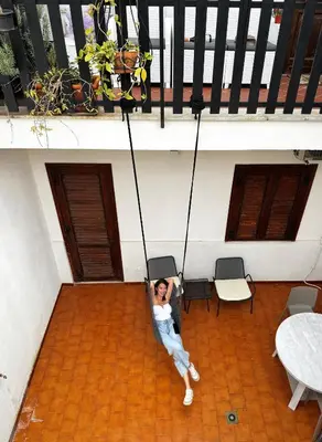 a woman is sitting on a swing in a building at Casa Antigone 99 in Mondello