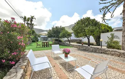 a pizza oven sitting next to a wall with plants at SEALAND TERRASINI in Terrasini