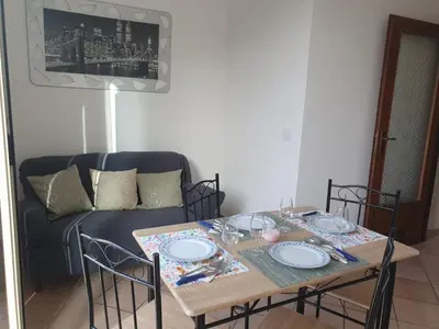 a table and chairs with a couch in a living room at AI CANTIERI in Palermo