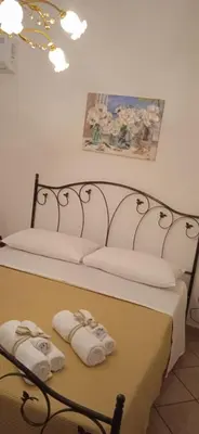 a bed with two folded towels on top of it at AI CANTIERI in Palermo