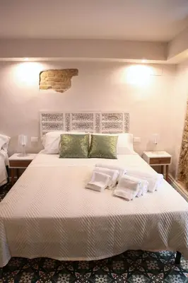 a bedroom with a large white bed with two pillows at Alle Absidi della Cattedrale in Palermo