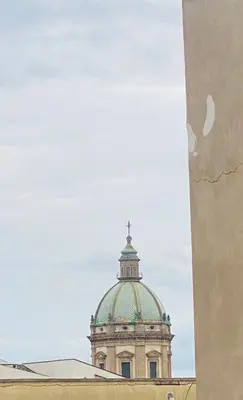a dome of a building with a cross on top at casetta della cattedrale in Palermo