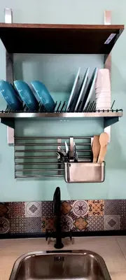 a kitchen counter with a sink and a shelf with utensils at casetta della cattedrale in Palermo