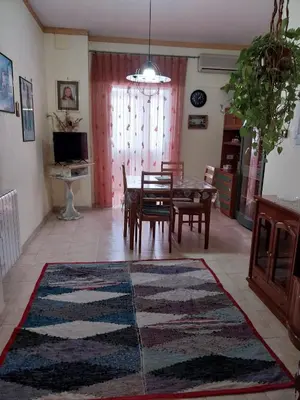 a living room with a table and chairs and a rug at ROOM VISTAMARE PALERMO in Palermo