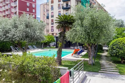 a swimming pool in a park with trees and buildings at GuestHost - Palermo Modern Apartment with Swimming Pool in Palermo