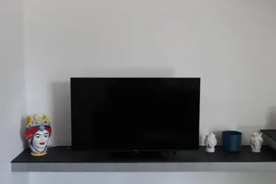 a living room with a staircase and a couch and a tv at Villa Stesicoro Suite in Mondello