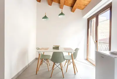 a kitchen with a table and chairs and a window at Vicolo del Capo in Palermo