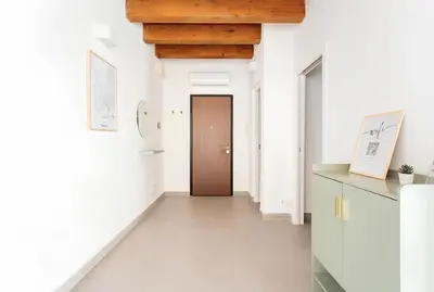 a hallway with white walls and a brown door at Vicolo del Capo in Palermo