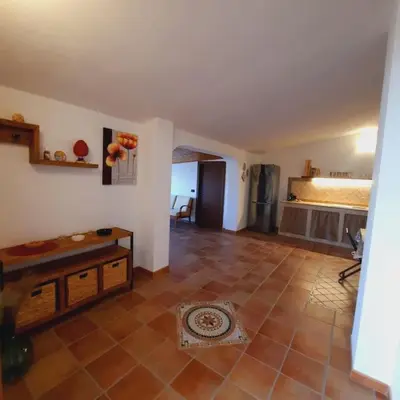 a living room with a tile floor and a kitchen at La Rosa dei venti in Calatafimi