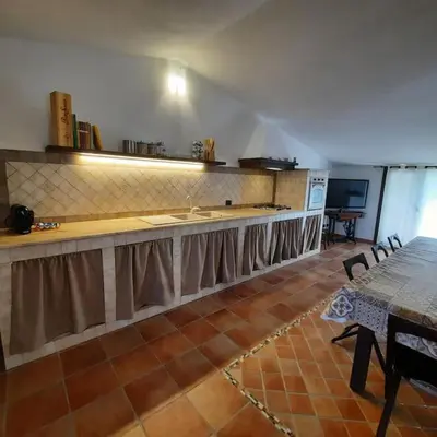 a kitchen with a counter and a table with chairs at La Rosa dei venti in Calatafimi