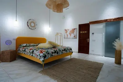 a bedroom with a yellow bed and a rug at Ischia suite in Termini Imerese