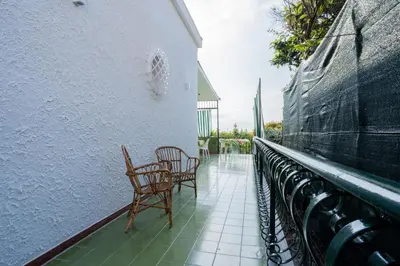 two chairs and a table on a balcony at Ischia suite in Termini Imerese
