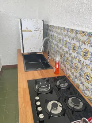 a kitchen with a stove top with a sink at Ischia suite in Termini Imerese