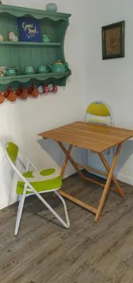 a wooden table and a green chair next to a table at La Casa di Chico in Mondello