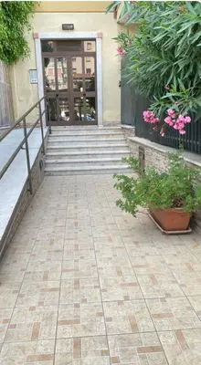 a front door of a building with pink flowers at Rosdani Apartment in Palermo