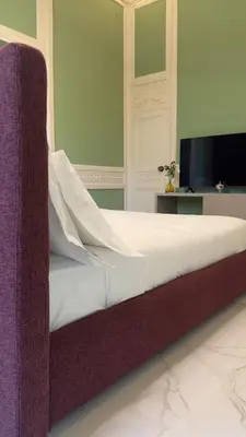 a bedroom with a bed and a tv on a wall at Palazzo Maqueda in Palermo