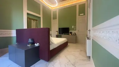 a bedroom with a bed with a purple headboard at Palazzo Maqueda in Palermo