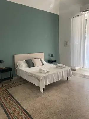 a bedroom with a large bed with blue walls at Stazione Armò in Palermo