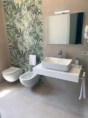 a bathroom with a sink and a toilet and a mirror at Coral Sand bed and breakfast in San Vito lo Capo