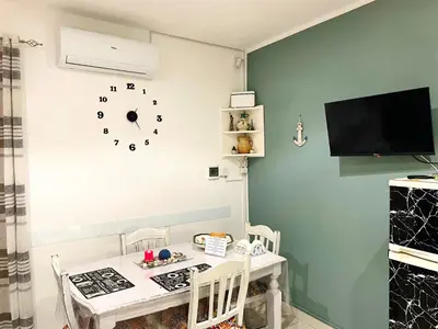 a dining room with a table and a clock on the wall at Casa Diema in Palermo