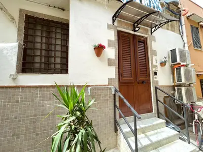 a house with a wooden door and stairs at Casa Diema in Palermo