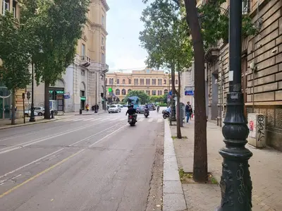 a person riding a motorcycle down a city street at Casetta Polì- Appartamento con terrazza - Centro Storico in Palermo