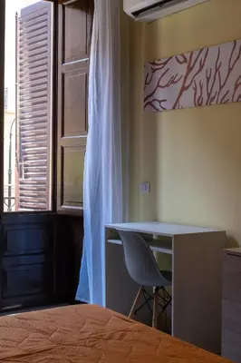 a bedroom with orange walls and a bed and a mirror at CORNER ROME appartamento in Palermo