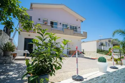 a white house with plants in front of it at holiday inn endless summer in Alcamo