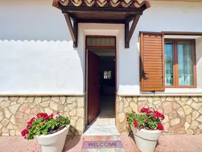 a house with two flower pots in front of a door at Villa Genova in Carini