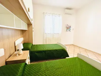 a room with a green bed and a green couch at Villa Genova in Carini