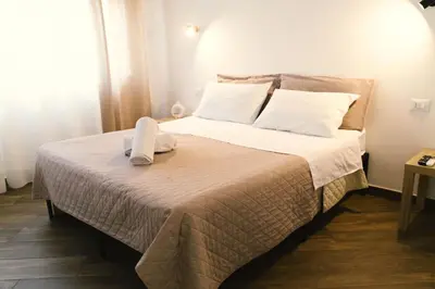 a bedroom with a large bed with white sheets and pillows at Galka Rooms in Palermo