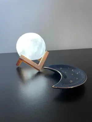 a table with a lamp and a plate with a moon at Galka Rooms in Palermo