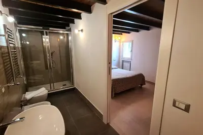 a bathroom with a toilet and a shower and a bed at Antica Dimora in Termini Imerese