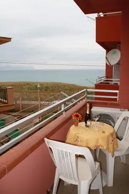 a table and chairs on a balcony with a view of the ocean at GB Case Vacanze Sicilia in Balestrate
