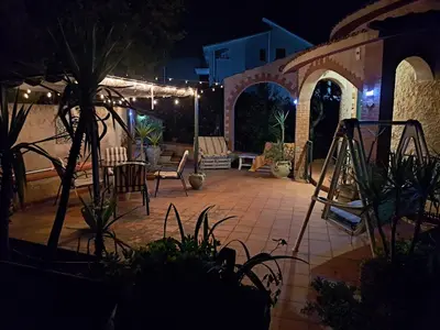 a patio at night with a table and chairs at Villa Paola appartamento completo in Ciminna
