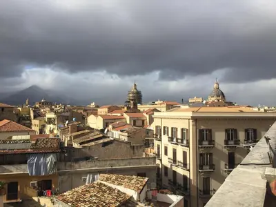 a view of a city with storm clouds in the background at Due Cani Apartment in Palermo