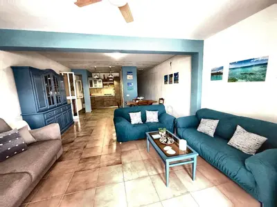 a living room with a blue couch and a table at Casa Alamar 100 metri dal mare in Alcamo