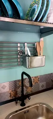 a kitchen counter with a sink and plates on a shelf at suite della cattedrale in Palermo