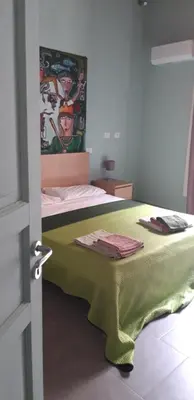 a bedroom with a bed with a green blanket on it at suite della cattedrale in Palermo